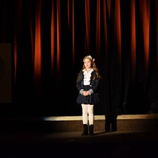 Na scenie uczestniczka recytująca wiersz podczas konkursu