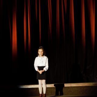 Na scenie uczestniczka konkursu podczas recytacji wiersza
