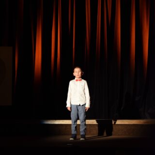 Na scenie uczestnik konkursu podczas recytacji wiersza