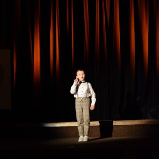Na scenie uczestnik konkursu podczas recytacji wiersza