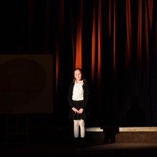 Na scenie uczestniczka konkursu podczas recytacji wiersza