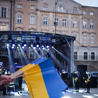 Flagi Ukrainy, w tle scena oraz gorlicki Ratusz.