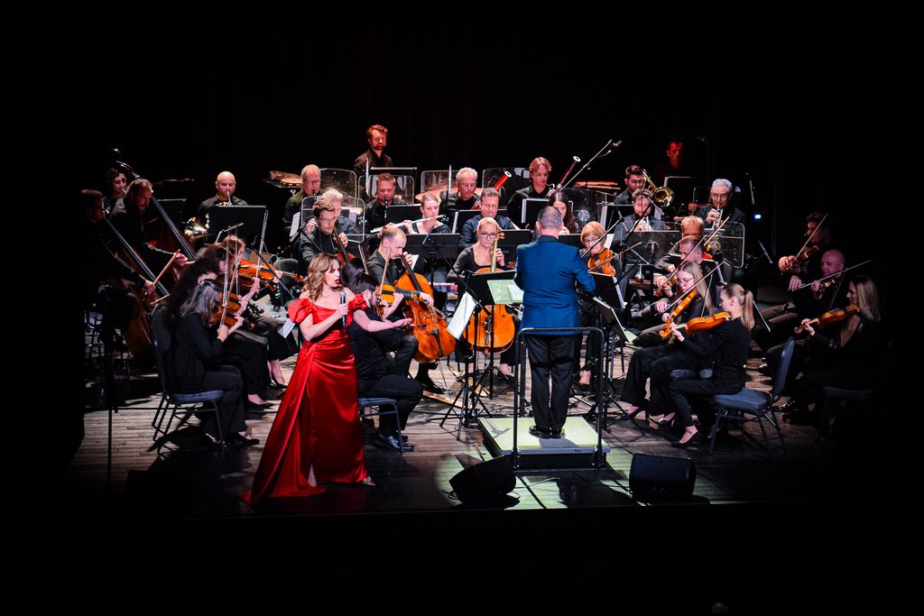 Zdjęcie przedstawiające orkiestrę Filharmonii Krakowskiej wraz z solistką.